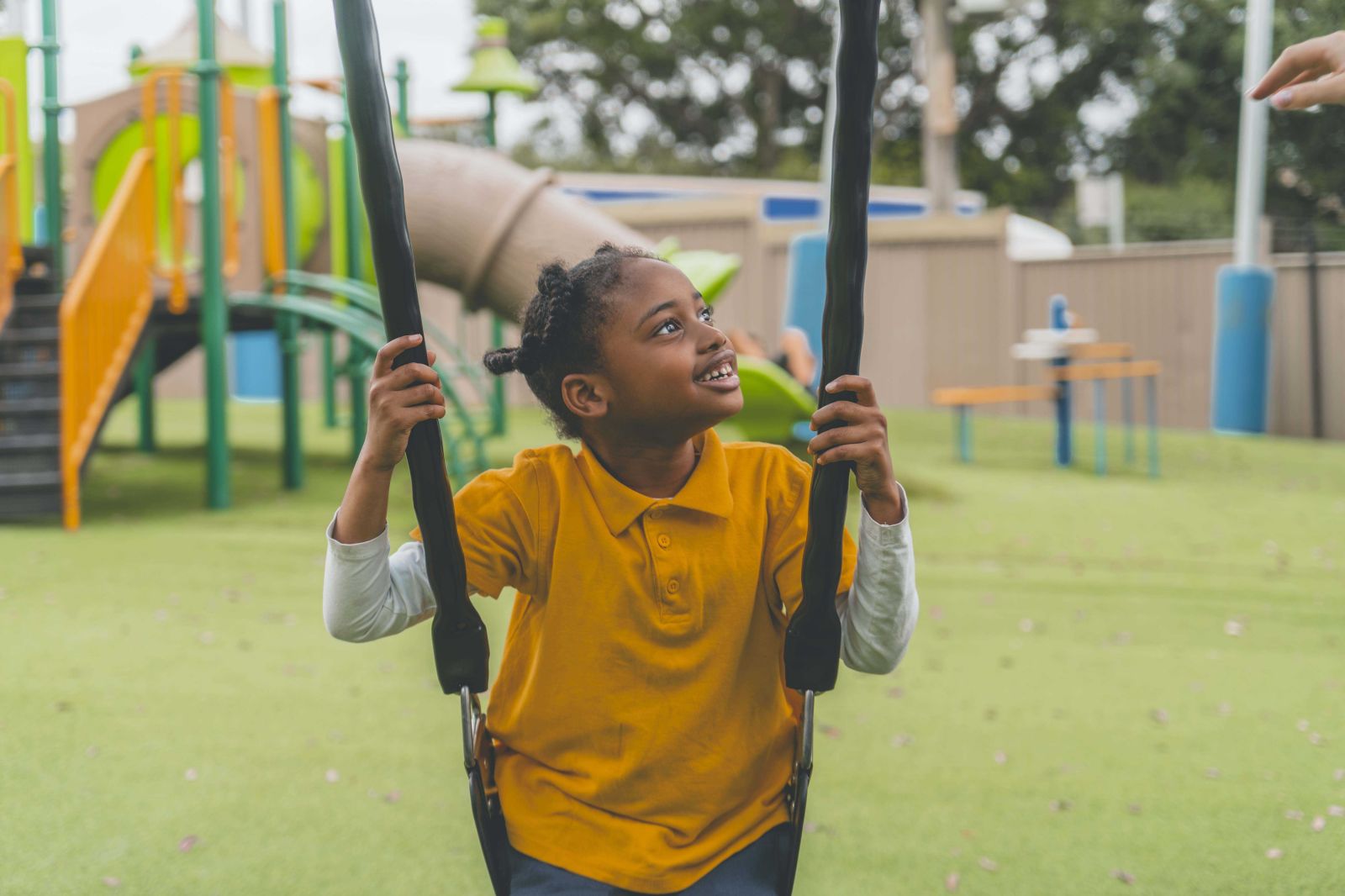 Student enjoying swing in school playground